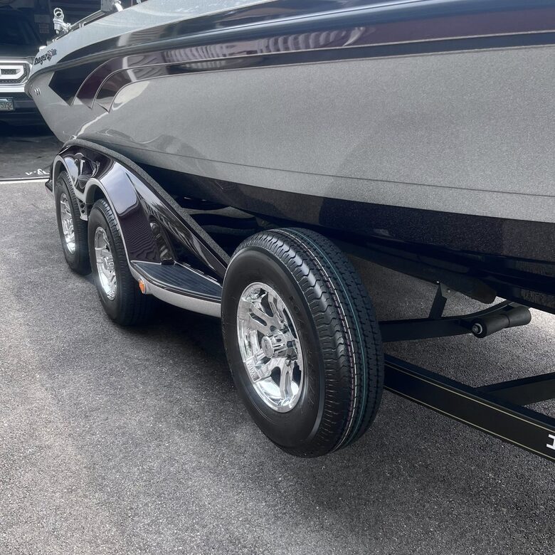 Glossy detailed boat hull and polished trailer wheels by OG Detailing in Huntley, IL